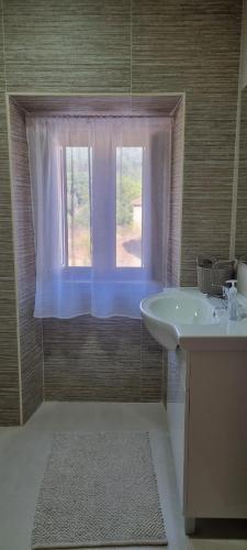 a bathroom with a sink and a window at Casa Pregueira in Lisboinha