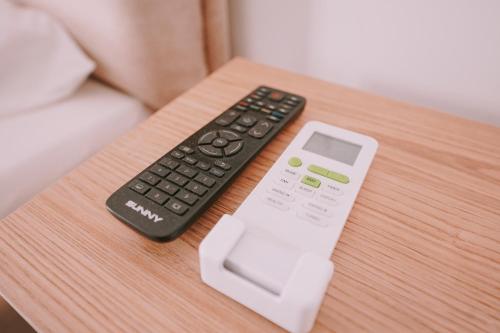 a remote control and a thermometer on a table at Vila Milo in Himare