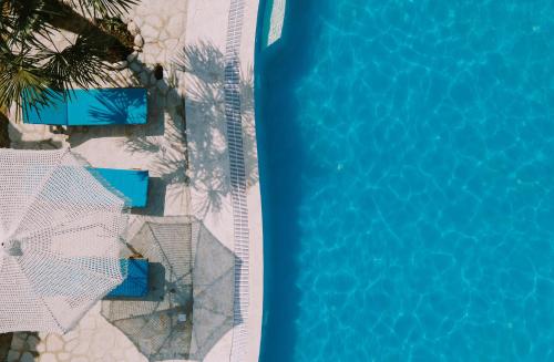 an overhead view of a swimming pool with blue water at Vila Milo in Himare