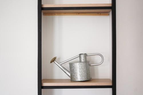 a metal tea pot on a wooden shelf in a room at Vila Milo in Himare