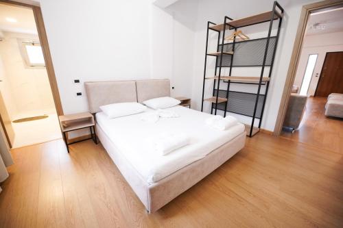 a bedroom with a white bed and a bunk ladder at Vila Milo in Himare