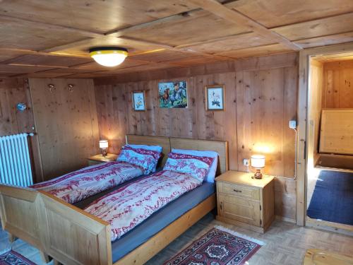 a bedroom with a bed and two night stands at Appartamento Col di Lana Dolomites in Livinallongo del Col di Lana