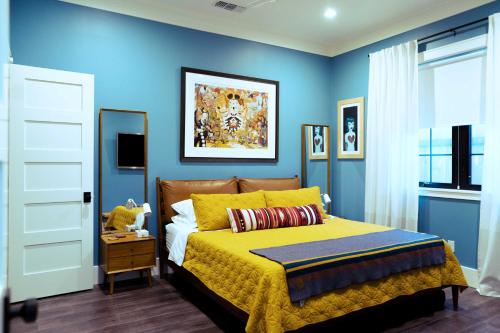 a bedroom with blue walls and a bed with a yellow bedspread at Sacramento Guest House with Patio about 5 Mi to Downtown in Sacramento
