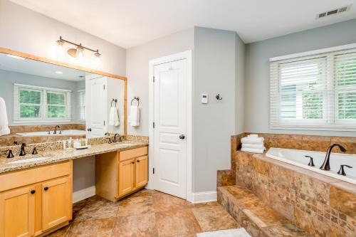 un bagno con due lavandini, una vasca e un grande specchio di Woodland Dreams a Swannanoa