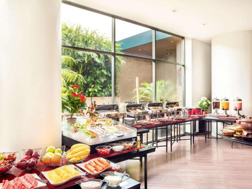 a buffet line with many different types of food at Ibis Jakarta Arcadia in Jakarta