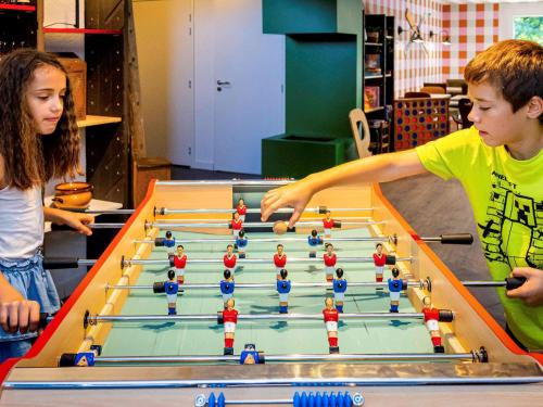 un garçon et une fille jouant au billard dans l'établissement greet hôtel Annecy Cran-Gevrier, à Annecy