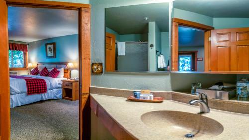 1 dormitorio con 1 cama y baño con lavabo. en Callahan's Lodge en Ashland