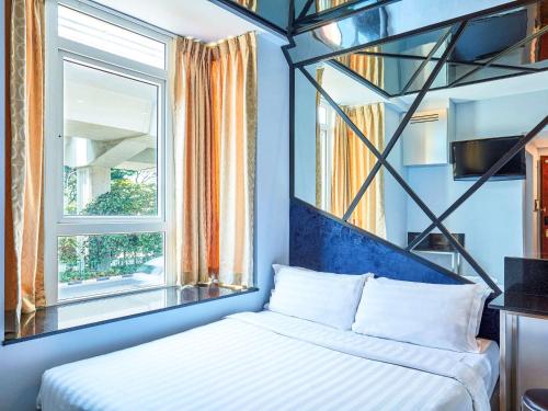 a bedroom with a bed and a window at ibis budget Singapore Mount Faber in Singapore