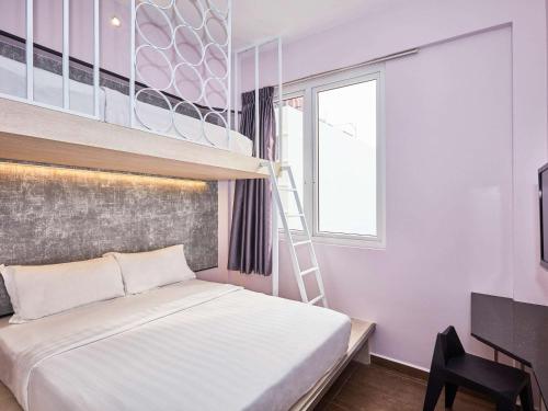 a bedroom with a bunk bed and a ladder at ibis budget Singapore Pearl in Singapore