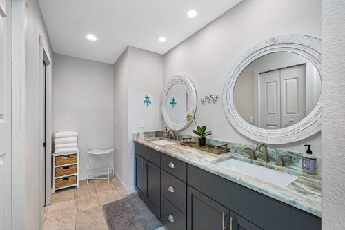 baño con lavabo y espejo grande en Breathtaking Waterfront Crystal Beach Getaway!, en Palm Harbor