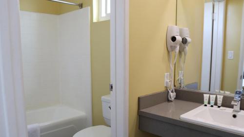 a bathroom with a white toilet and a sink at Hometel Suites in Los Angeles