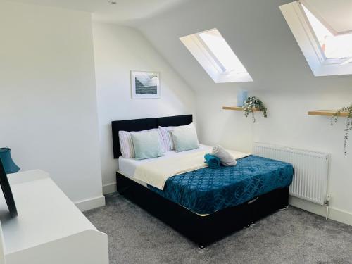 ein Schlafzimmer mit einem Bett und zwei Oberlichtern in der Unterkunft Castle view Rochester in Rochester