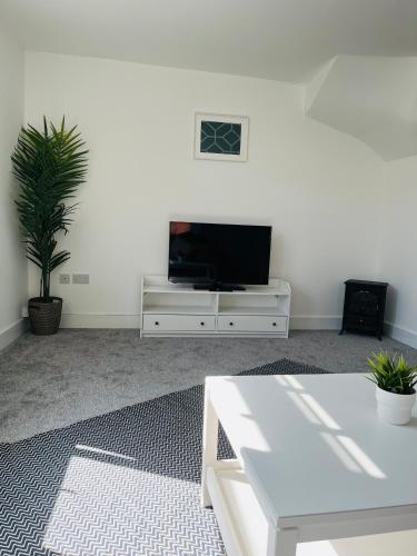 a living room with a white table and a tv at Castle view Rochester in Rochester
