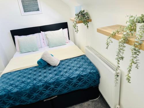 a small bedroom with a bed with blue and white sheets at Castle view Rochester in Rochester