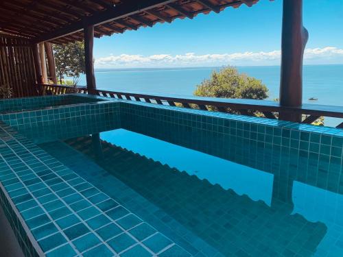 a swimming pool with a view of the water at Altavista residence in Morro de São Paulo