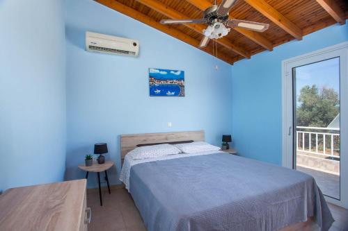 1 dormitorio azul con 1 cama y ventilador de techo en Villa Hercules, en Kremasti