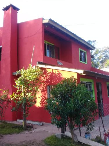 a red house with two trees in front of it at Nuestro Paraiso in Mar del Plata