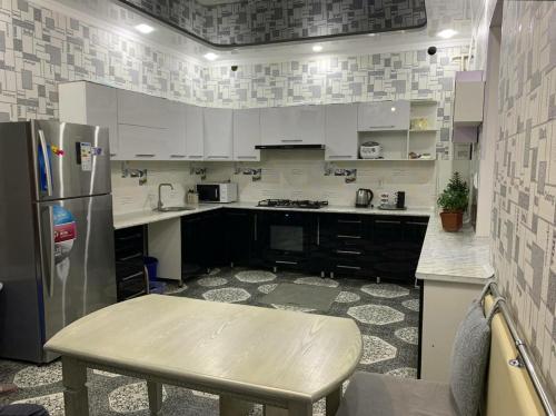 a kitchen with white cabinets and a stainless steel refrigerator at Green house in Nukus