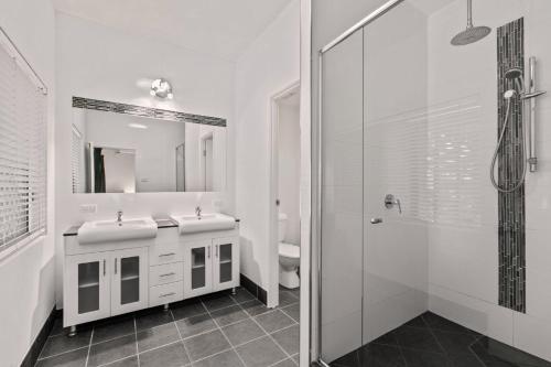 a bathroom with two sinks and a shower at Ivy Street 7 Dicky Beach in Caloundra