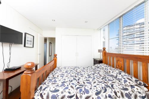 Un dormitorio con una cama y una ventana grande. en Ebbtide, Unit 04, 2-6 North Street, en Forster