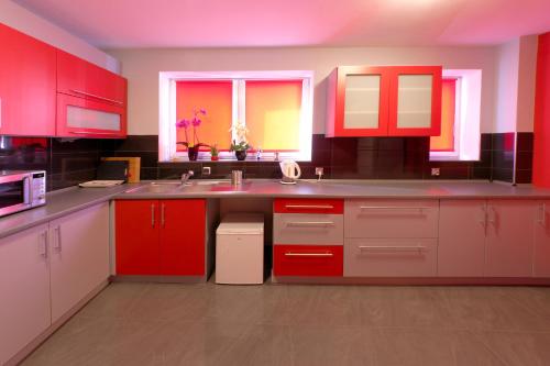 a kitchen with red cabinets and a sink at Willa Luiza in Wisła