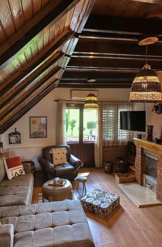 a living room with a couch and a fireplace at Vikendice Stara Pruga in Gornji Milanovac