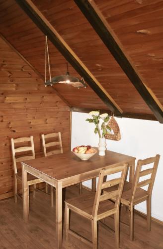a wooden table and chairs in a room with a ceiling at Vikendice Stara Pruga in Gornji Milanovac