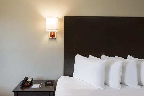a hotel room with a bed and a phone on a table at Days Inn by Wyndham Somerset PA I-70 I-76 in Somerset