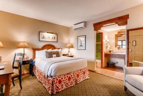 a hotel room with a bed and a desk and a bathroom at Old Santa Fe Inn in Santa Fe