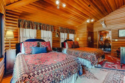 a bedroom with two beds in a room with wooden walls at Antler River Lodge in Guerneville