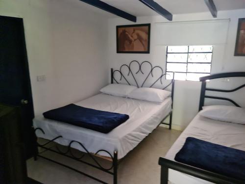 Habitación pequeña con 2 camas y ventana en Finca Hotel Alto la María, en Angelópolis