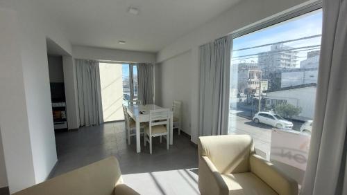 a living room with a couch and a table and a window at Amanecerpuertomadryn 1 in Puerto Madryn
