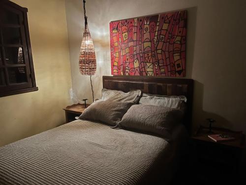 una camera da letto con un letto e un dipinto sul muro di Casas da Paty a Santana do Riacho