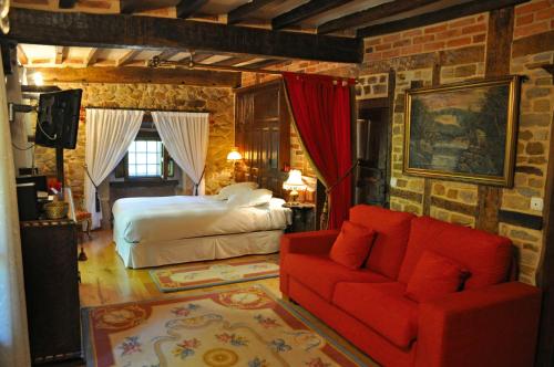 a bedroom with a bed and a red couch at Palacio de Trasvilla in Escobedo