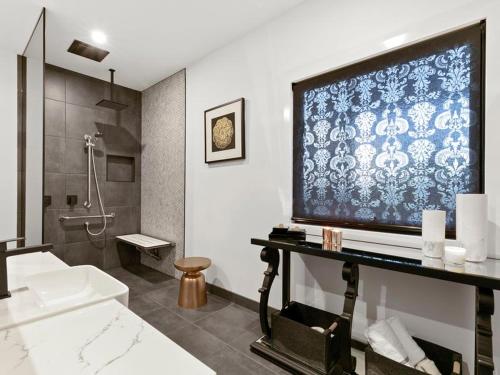 a bathroom with a large tv on the wall at Campania Non Spa Suite in Meeniyan