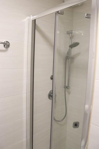 a shower with a glass door in a bathroom at Relaxon Guest House in Rome