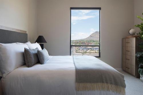 a bedroom with a large bed and a large window at Sentral Old Town in Scottsdale