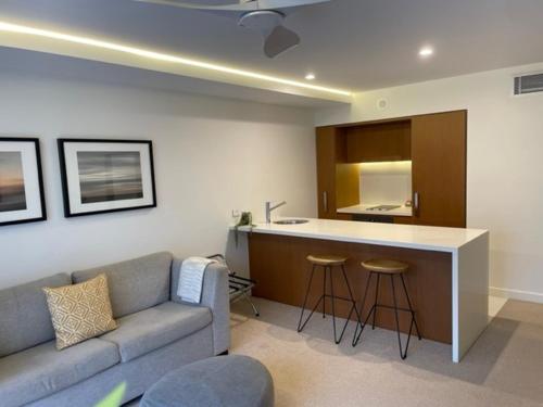 a living room with a couch and a kitchen at Il Palazzo Holiday Apartments in Cairns