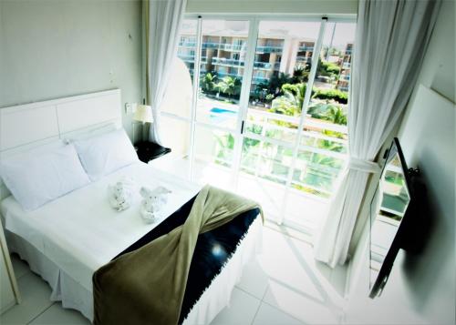 1 dormitorio con cama y ventana grande en BEACH PARK PALM - COBERTURA Luxo en Aquiraz