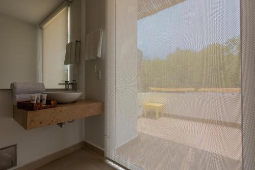 a bathroom with a sink and a large window at Santo Manglar Cartagena Life Wellness Spa Hotel in Cartagena de Indias