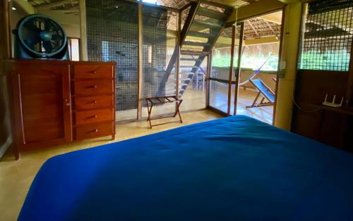 a bedroom with a blue bed and a chair at Cabaña DREAM HOUSE in San Agustinillo