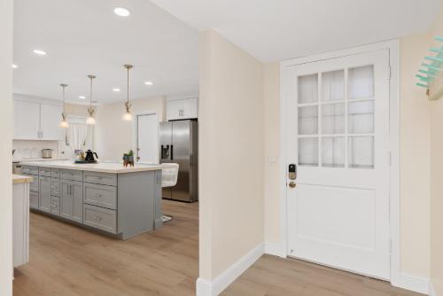 a kitchen with white cabinets and a white door at Golf - Beach - Legoland - Shopping - Dining in Carlsbad