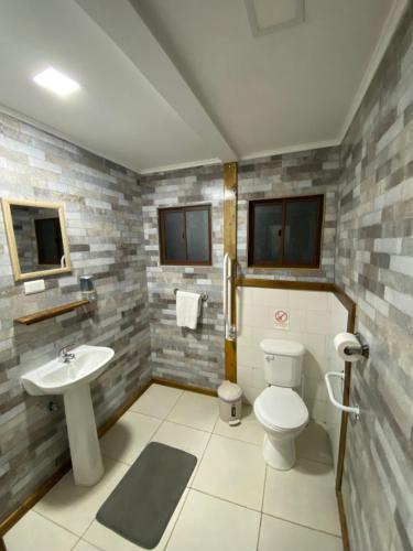 a bathroom with a toilet and a sink at Konkashken Lodge in Torres del Paine