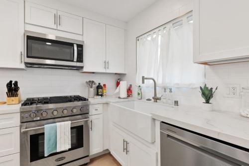 a white kitchen with a stove and a microwave at Golf - Beach - Legoland - Shopping - Dining in Carlsbad