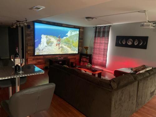 uma sala de estar com uma grande televisão de ecrã plano em Cute 2-BRM Walkout apt with pool table and theater em Lexington