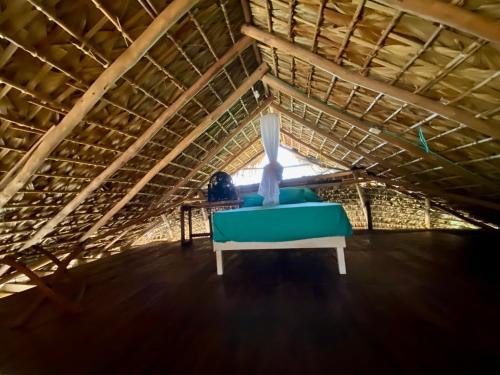 a blue couch sitting in the middle of a attic at Cabaña con vista al mar y wifi Starlink en San Agustinillo in San Agustinillo