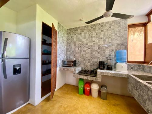 a kitchen with a stainless steel refrigerator in a room at Cabaña con vista al mar y wifi Starlink en San Agustinillo in San Agustinillo