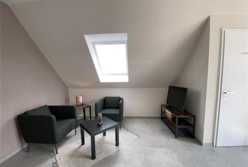 a living room with two chairs and a tv at Studio - Apartment Steinmetz mit Balkon in Reken