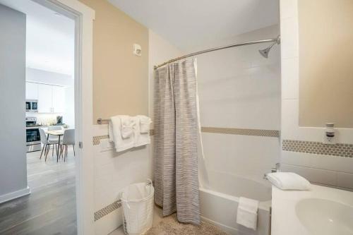 a white bathroom with a tub and a sink at Stylish 1br Unit. Parking. Easy Ride to NYC in Hackensack