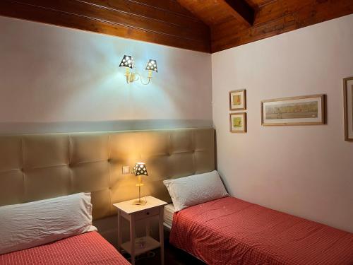 a bedroom with two beds and a table with a lamp at Villa Charly in Puerto de la Madera